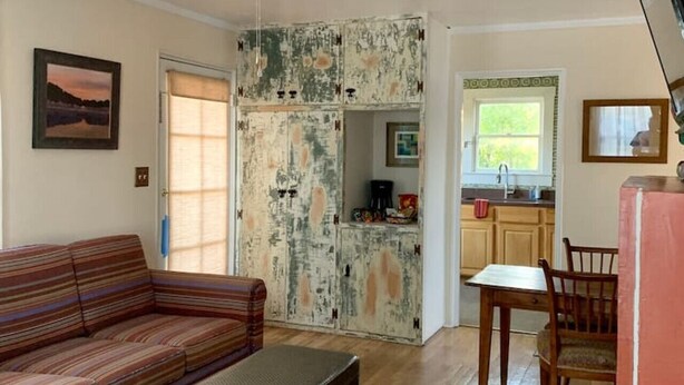 A living room with a sofa, a coffee table, and a dining area with a table and chairs. There is a kitchen visible through an open door. - 2 bed and pullout sofa kids and dogs welcome (Las Cruces)