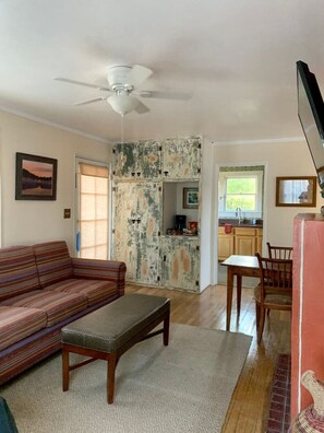 A living room with a sofa, a coffee table, and a dining area with a table and chairs. There is a kitchen visible through an open door. - 2 bed and pullout sofa kids and dogs welcome (Las Cruces)