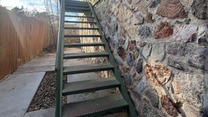 A wooden staircase leading up to a house with a stone exterior wall. - 2 bed and pullout sofa kids and dogs welcome (Las Cruces)