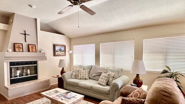 A living room with a fireplace, a sofa, a coffee table, and a ceiling fan. - 2 bd/2bth near NMSU and Memorial Medical Center (Las Cruces)