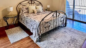 A bedroom with a bed, a ceiling fan, a window with a view, and a patterned rug. - 2 bd/2bth near NMSU and Memorial Medical Center (Las Cruces)