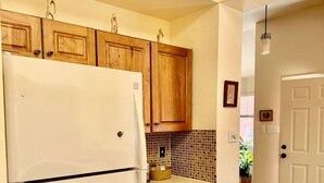 A kitchen with wooden cabinets, a white refrigerator, a tiled backsplash, and a wooden countertop. - 2 bd/2bth near NMSU and Memorial Medical Center (Las Cruces)