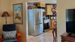 Una sala de estar con un sofá, un televisor y un cuadro en la pared.