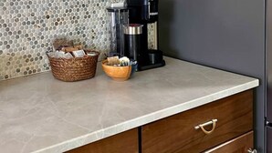 A kitchen with a coffee maker, a basket, and a bowl on the counter. - 1 bed W/D in unit, soaker tub near Field of Dreams (Las Cruces)