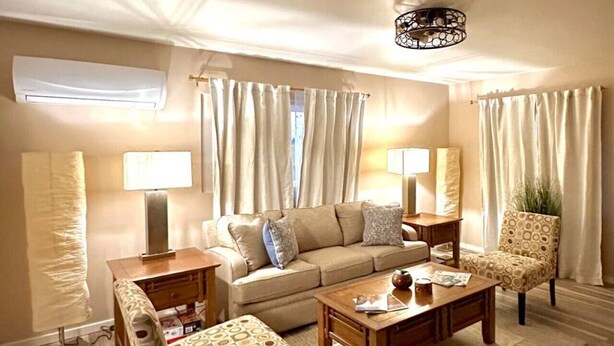 A living room with a sofa, two armchairs, a coffee table, and a lamp. - 1 bed W/D in unit, soaker tub near Field of Dreams (Las Cruces)