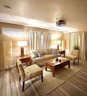A living room with a sofa, two armchairs, a coffee table, and a lamp. - 1 bed W/D in unit, soaker tub near Field of Dreams (Las Cruces)
