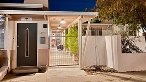 A hotel entrance with a dark door, a number '420' sign, and a covered walkway leading to the entrance.