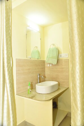 Un baño con lavabo, espejo y barra para toallas.