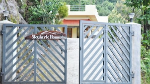 A gated entrance to Skylark Homestay with a signboard.