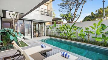 Una piscina al aire libre, sillones reclinables de piscina