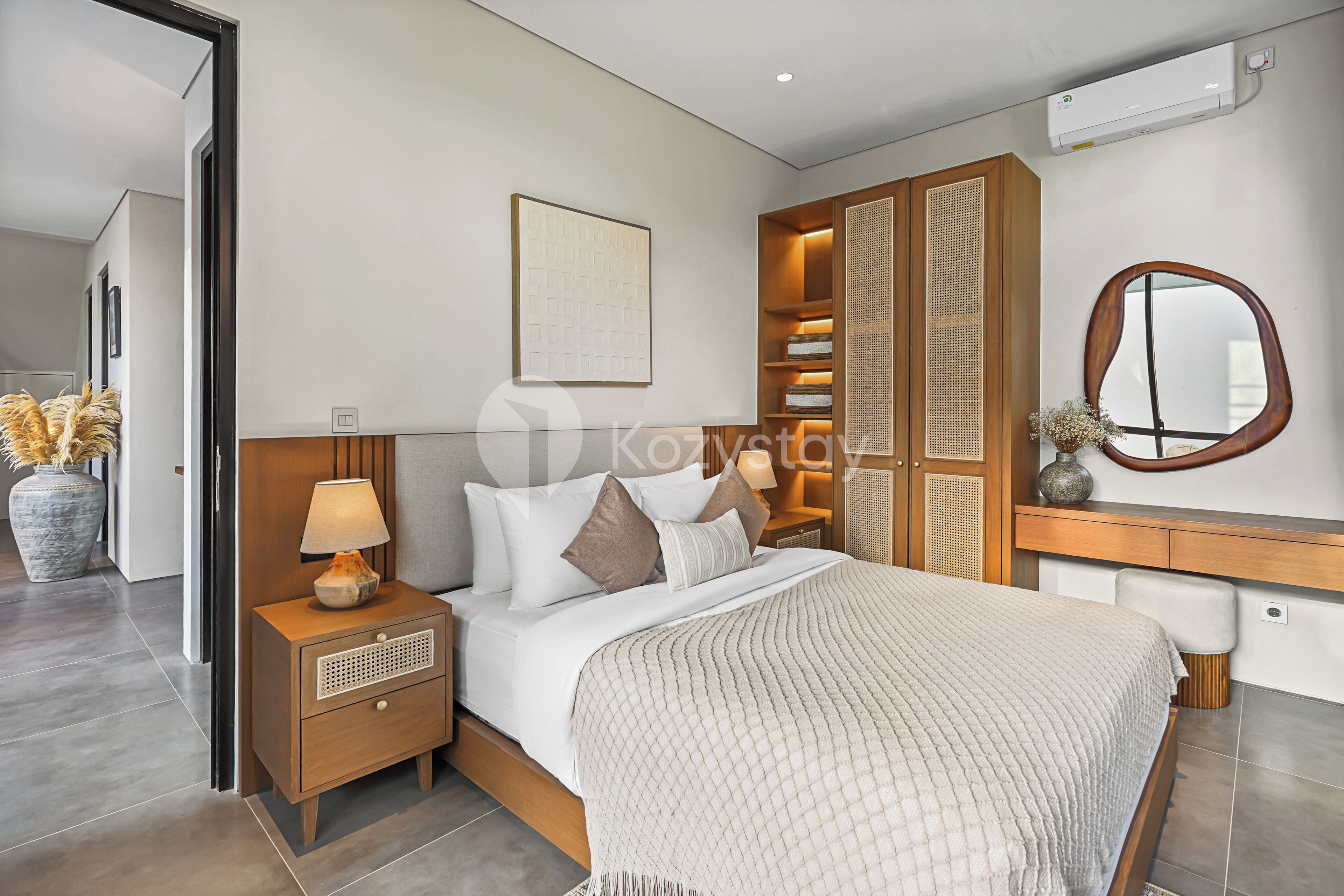 A modern bedroom with a bed, nightstands, a wardrobe, and a mirror.