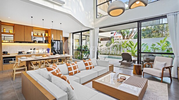 Een moderne, open woonkamer met keuken, eethoek en zithoek met uitzicht op de omgeving.