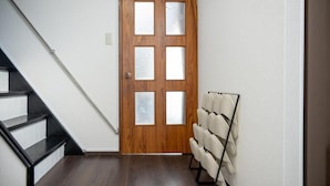 A wooden door with frosted glass panels, a staircase with black steps, and a wall-mounted chair rack. - BIEI RELAX STAY A (Biei)
