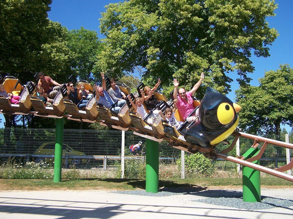 Une balançoire où enfants et adultes s’amusent en profitant du mouvement.