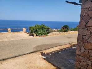 Una carretera costera con un muro de piedra y vista al mar.
