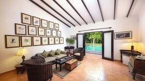 A spacious living room with a sofa, chairs, a coffee table, and framed artwork on the walls. - Villa Wild Ceylon by TSC (NW)