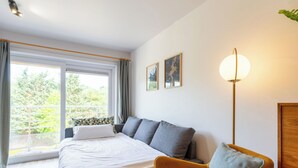 A modern bedroom with a bed, a sofa, and a floor lamp.