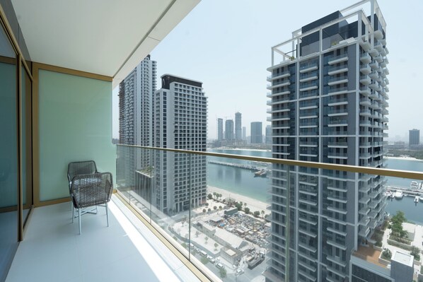 A balcony with a view of high-rise buildings and a marina.