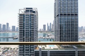 A high-rise building with a view of a marina and other tall buildings in the background.