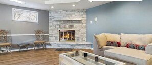 Un salon moderne avec une cheminée en pierre, un canapé et une table basse.