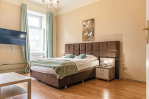 A bedroom with a bed, bedside table, lamp, and a painting on the wall. - Longstay 2BR Apt in Central Area (Vienna)