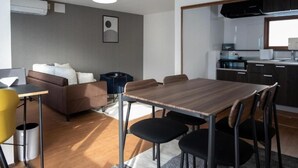 Un espace de vie compact comprenant un coin repas, une kitchenette et un canapé.