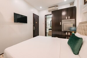 Une chambre d’hôtel équipée d’un lit, d’un téléviseur fixé au mur, d’une armoire et d’un appareil de climatisation.