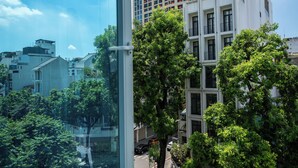 Un immeuble moderne à plusieurs étages, doté de grandes fenêtres et comprenant des espaces à usage résidentiel et commercial.