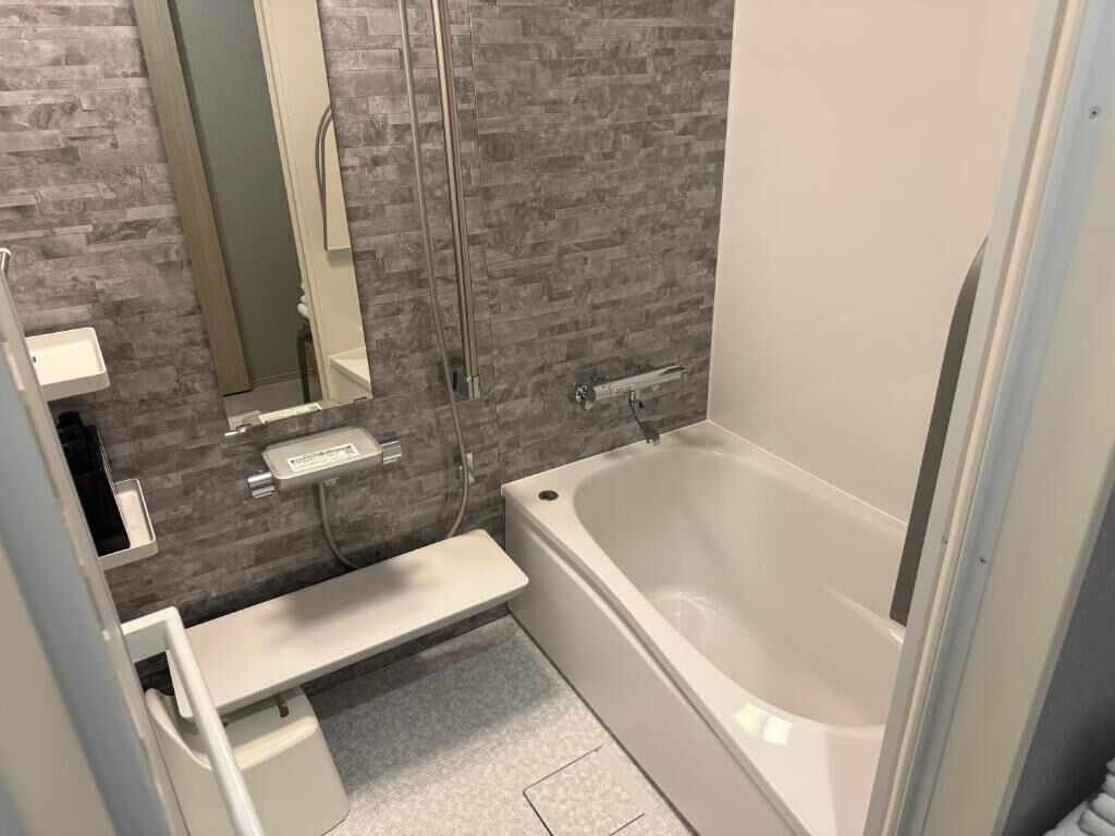 Un baño moderno con bañera, cabina de ducha de vidrio y un pequeño tocador con espejo.