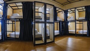 A room with bunk beds arranged in a circular layout, each with a curtain and a small table. - Poolside By Mingle (Kuala Lumpur)