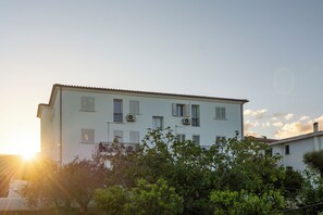 A multi-story building with balconies and air conditioning units. - Charming Baia Marina Apartment (Orosei)