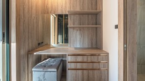 A modern bathroom with wooden cabinetry, a vanity with a mirror, and a bench. - Near Beach & Famous Boat Ave V217 (Choeng Thale)
