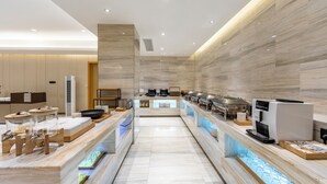 A modern hotel kitchen with a long counter, various appliances, and a seating area. - JI Hotel -Shanghai Changshou Road (Shanghai)