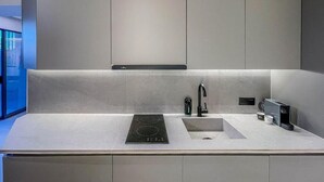 Eine moderne Küche mit eingebautem Herd, einer Spüle und einer eleganten Arbeitsplatte.