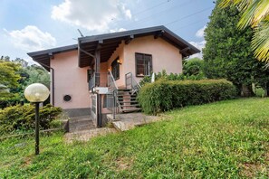 A two-story house with a porch, a staircase, and a well-maintained garden. - Unique Lake View in Green Park (Nebbiuno)