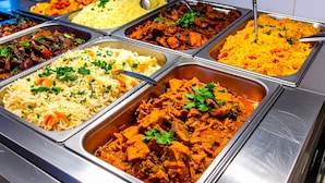 Buffet com diversos pratos, incluindo arroz, carne e legumes.