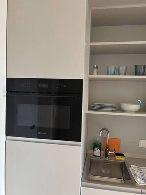 Fridge, microwave, coffee/tea maker, cookware/dishes/utensils