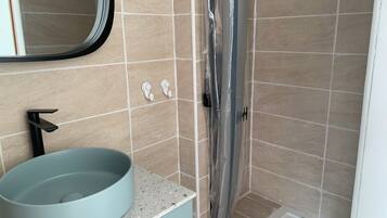 Regadera, secadora de cabello, toallas, papel de baño