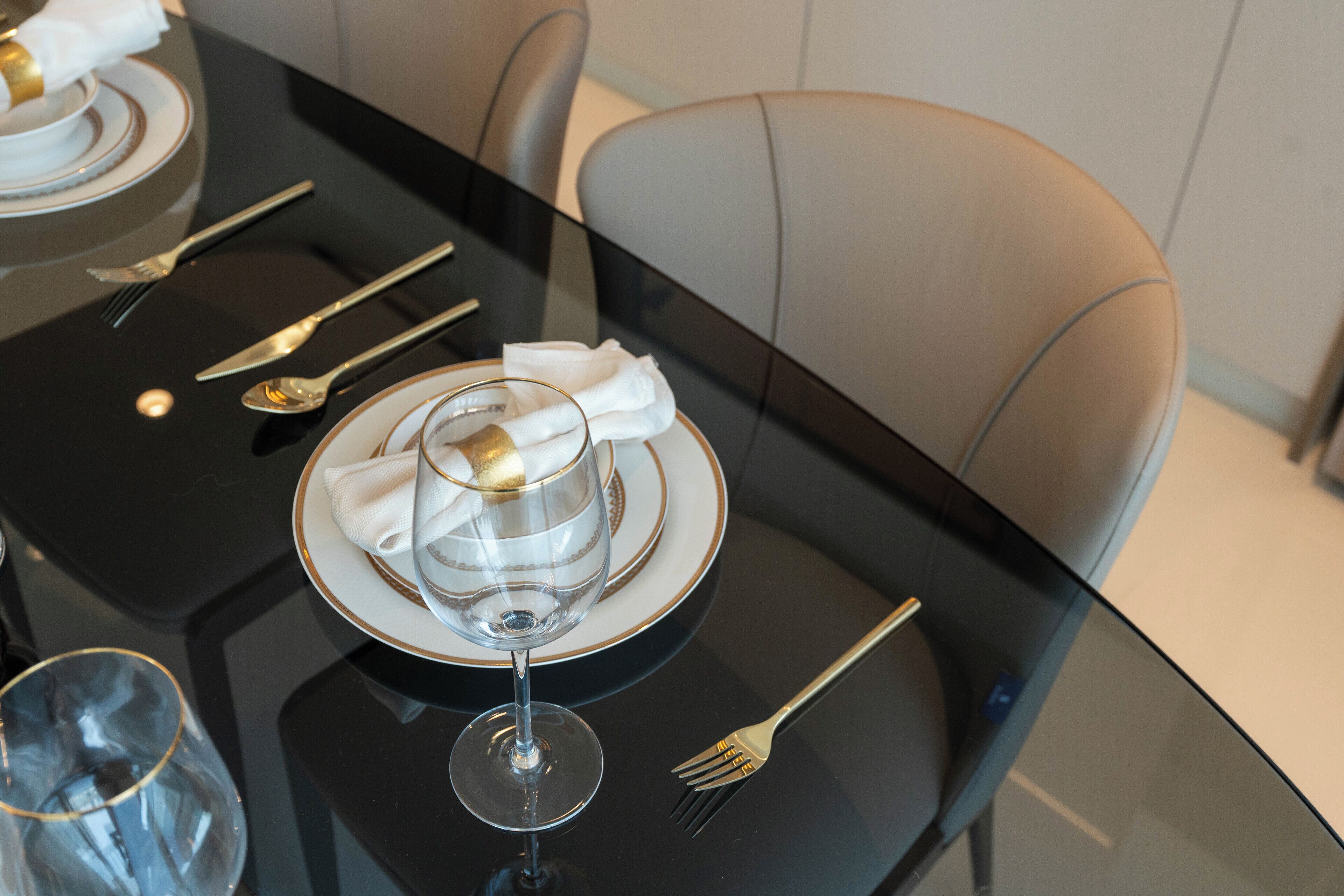 A dining table set with a glass, plate, and napkin, along with cutlery.