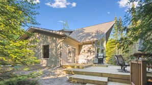 Une cabane en bois dotée d’une terrasse, entourée d’arbres.