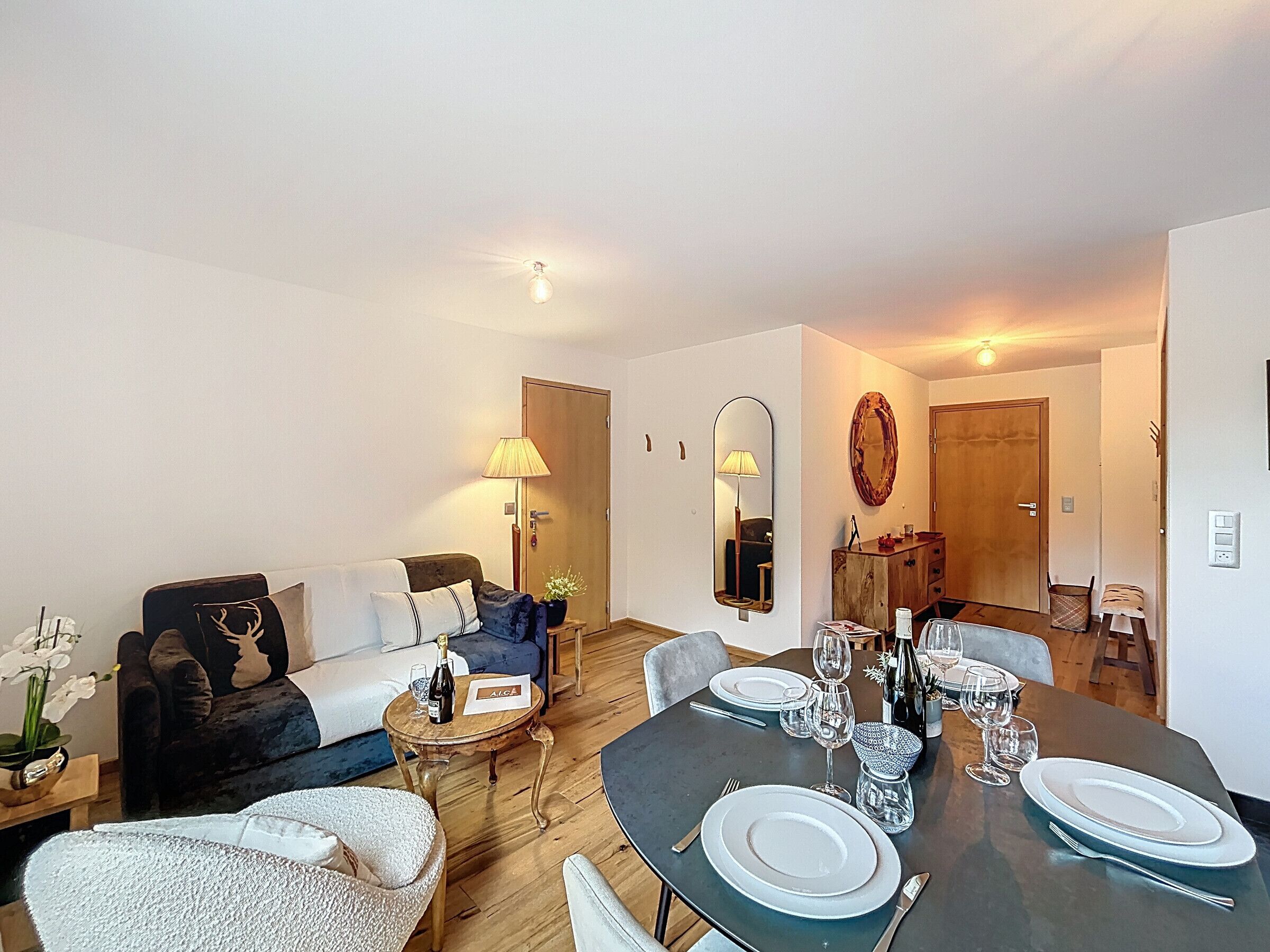 Un salon moderne avec un coin repas, comprenant un canapé, une table basse et une table à manger pour quatre personnes.