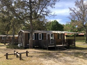 Une cabane en bois avec un porche et une zone délimitée par une clôture.