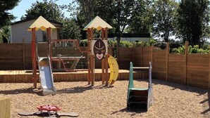 A playground with a slide, climbing structures, and a seesaw. - Mobile home with terrace in Saint-Gildas-de-Rhuys (Saint-Gildas-de-Rhuys)