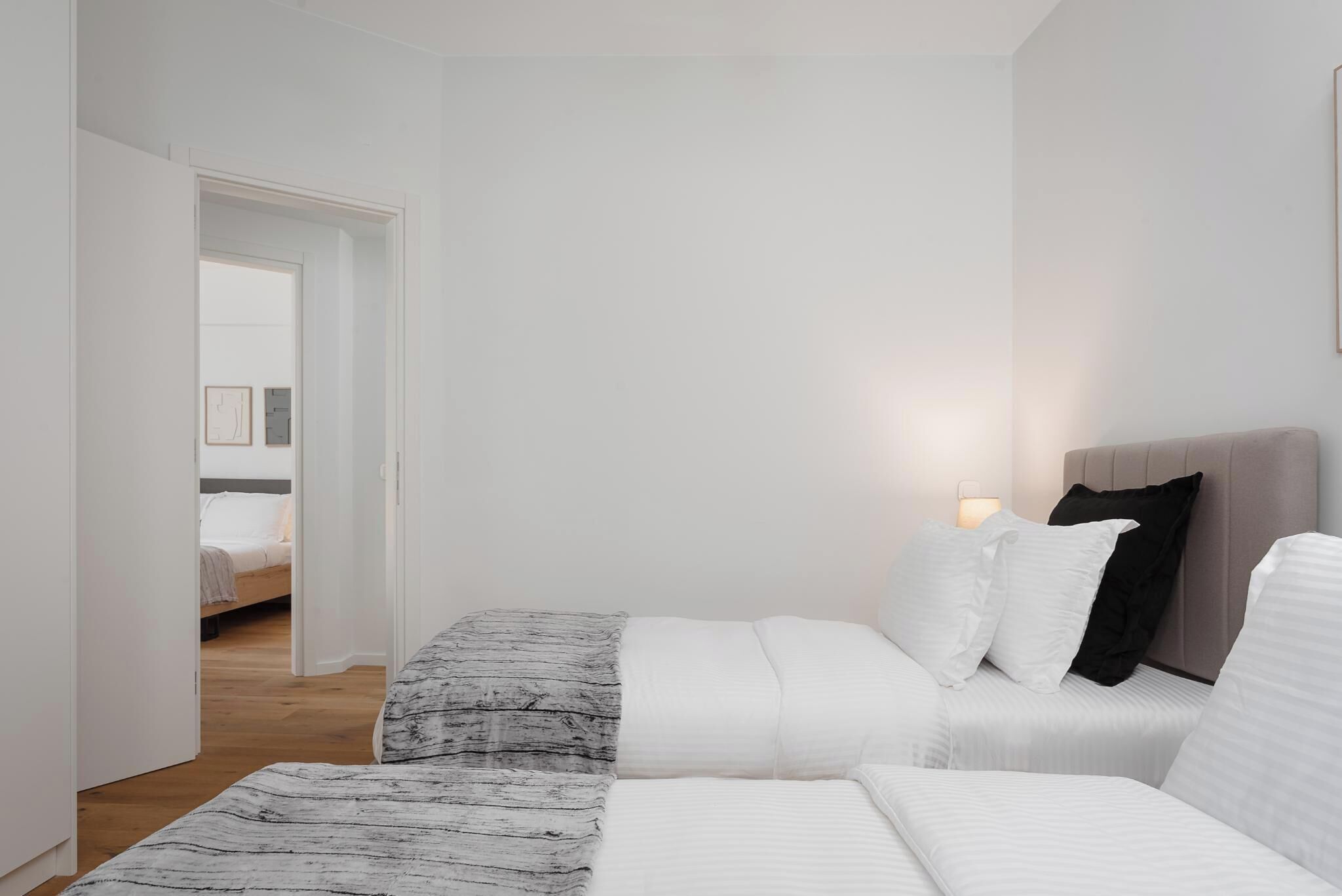 Un dormitorio moderno con cama, mesitas de noche y velador.