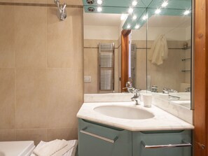 Ein Badezimmer mit Waschbecken, Spiegel und Handtuchhalter.