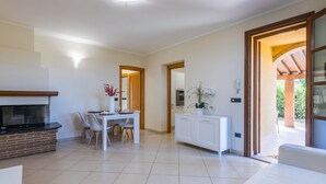 Ein modernes Wohnzimmer mit Kamin, Essbereich und Blick ins Freie.