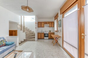 Uma cozinha compacta com armários de madeira, um fogão e uma mesa de jantar.