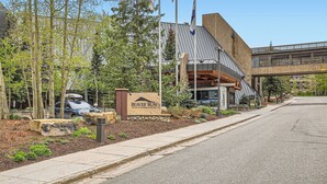 Een modern gebouw met een bord voor Beaver Run Resort & Conference Center, met een grote Amerikaanse vlag, een overdekte doorgang en een aangelegde entree.