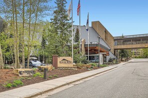 Un bâtiment moderne, sur lequel on peut voir une enseigne indiquant « Beaver Run Resort & Conference Center », avec un drapeau américain bien visible, une allée couverte et un espace d’entrée aménagé.