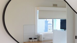 Una cocina con un refrigerador blanco, un microondas y una ventana sobre la encimera.
